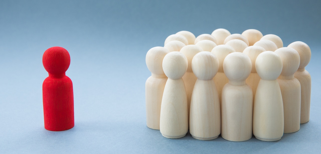A concept image of a person standing out from a crowd as a leader or inspirational teacher amongst men and women or being excluded because of being different - A Manager or Leader addressing a group of people or being isolated because of diversity - 1211628101
